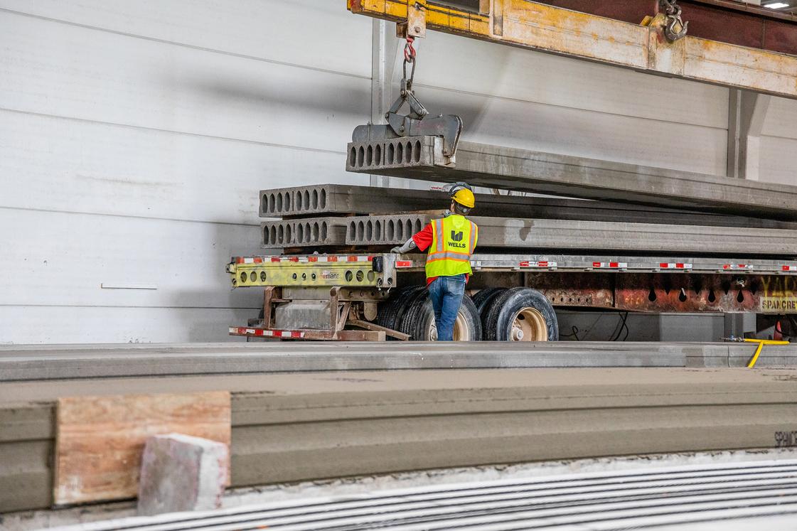 hollowcore planks being stacked onto truck in manufacturing facility