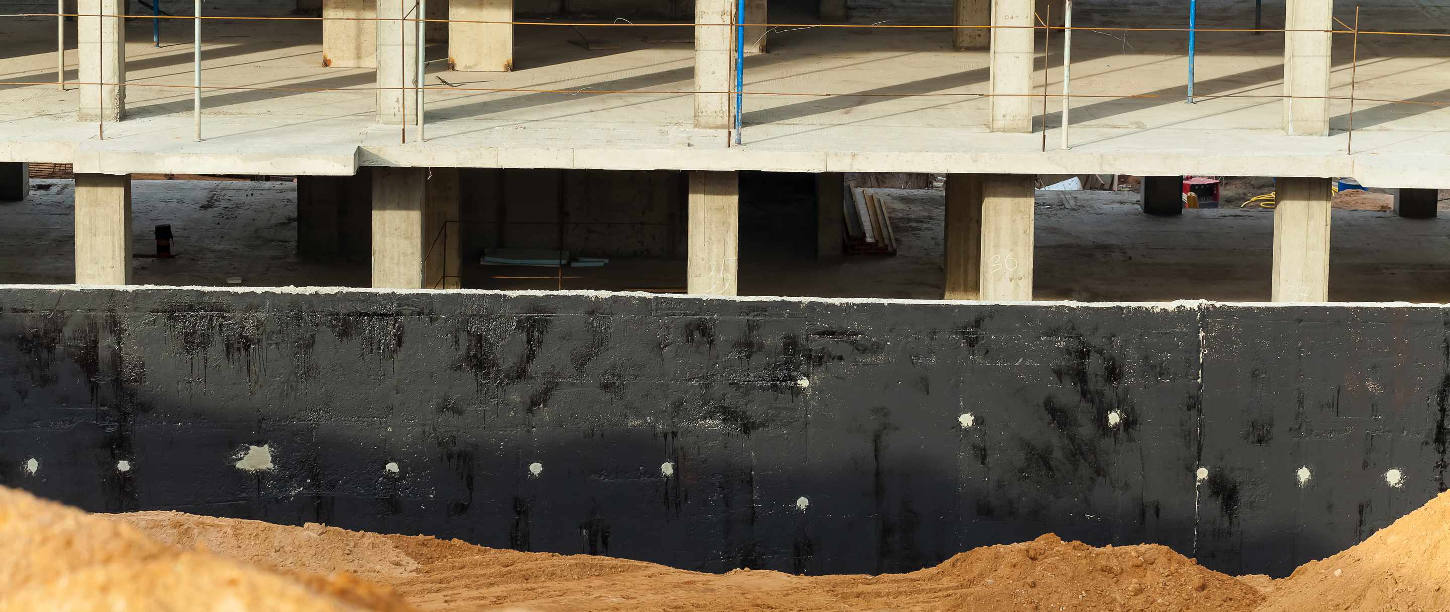 worker waterproofing a building