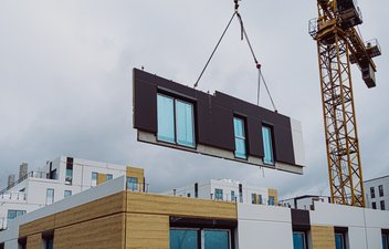a fully unitized panel being lifted by a crane