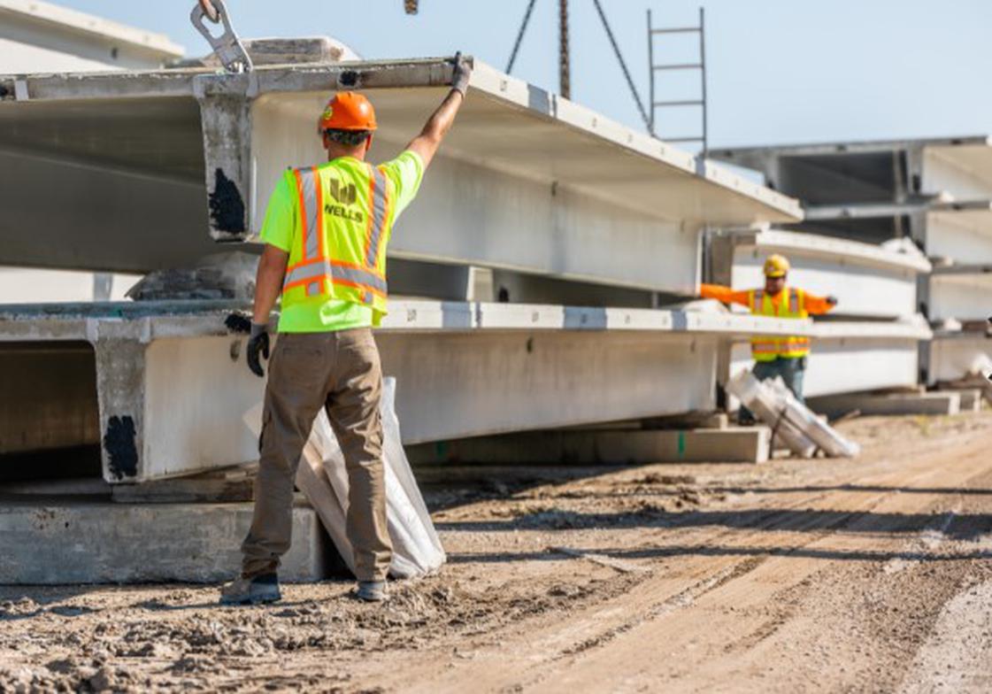 Workers in safety vests and helmets using analyzing operational efficiency of structure