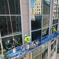 Image of maintenance workers sealing a high rise building