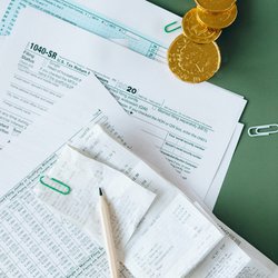 Image of receipts and forms with coins