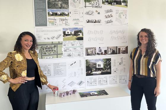 two students standing in front of their design contest submission