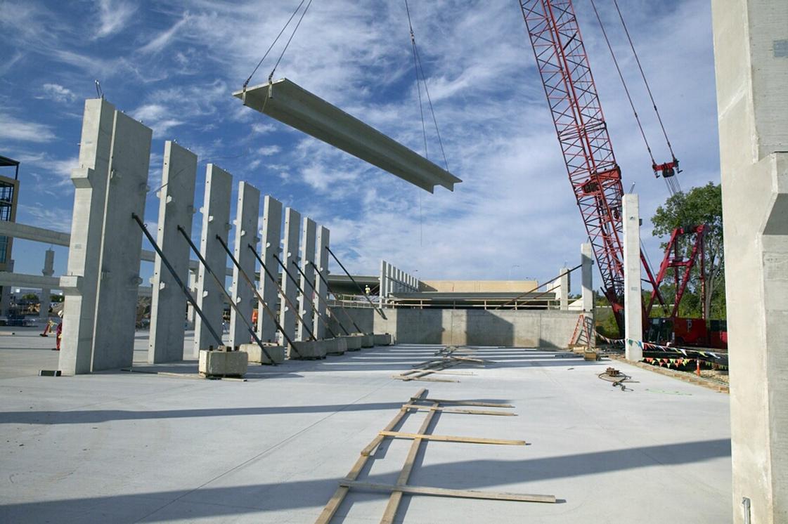 double tee in lifted by crane during construction with columns set up