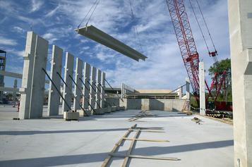 photo of double tee lifted by a crane during construction