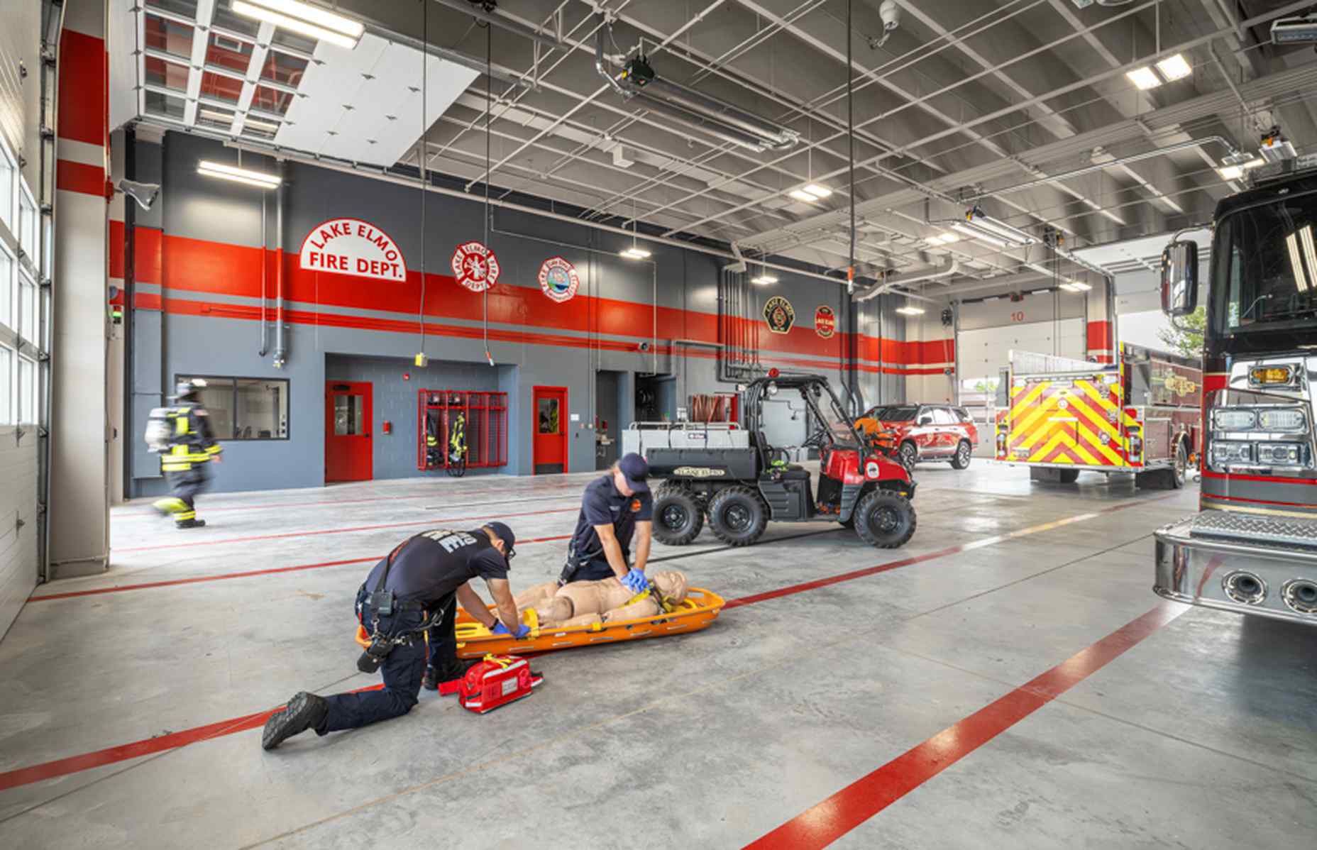 EMTs with a dummy in a fire station bay