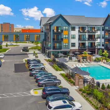 aerial of the exterior of the ruby apartments with pool, skywalk, and parking