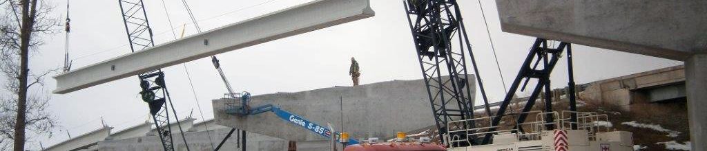 bridge girders being taken off a truck