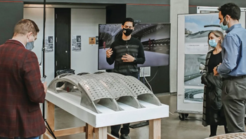 students presenting posters and project models to academics and industry professionals