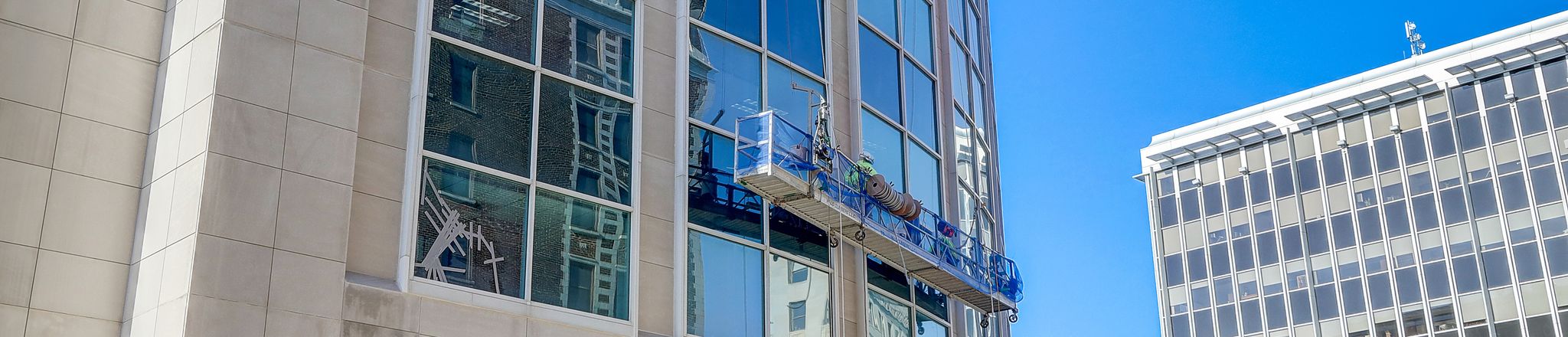 wells workers performing restorative services on building exterior