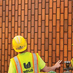 A contractor examining the finish of a section of facade.