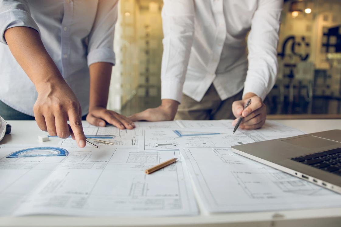 Engineers working at table over plans