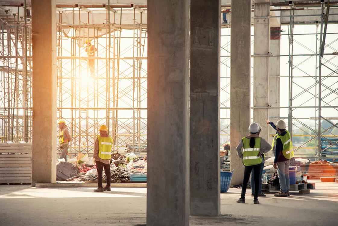 Workers on an job site with setting sun coming through windows