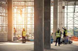 Workers on an job site with setting sun coming through windows