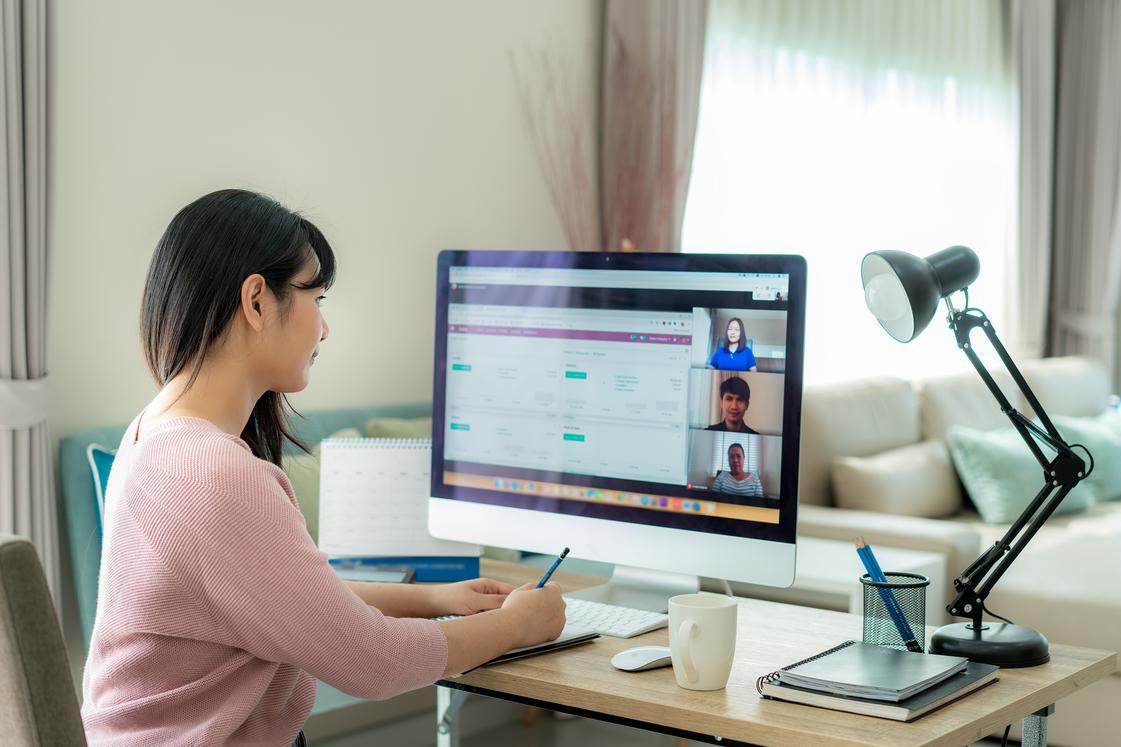 Woman videoconferencing in front of her computer at home